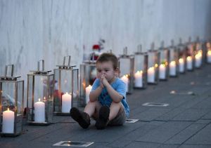 Blake Catanese sits near 40 candles at the Flight 93 Memorial Wall for ..."widows and orphans".